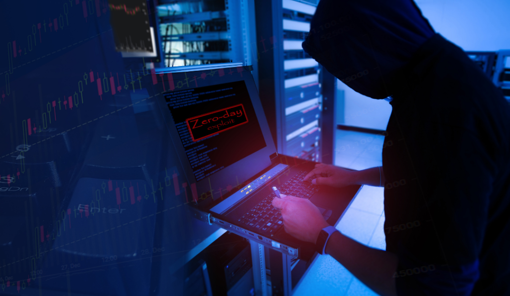 Guy in a hoodie with a USB device in his hands standing in front of a computer.